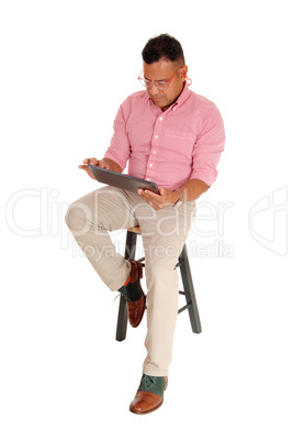 Hispanic man sitting with tablet pc.