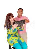 A middle age couple having fun with the tablet.