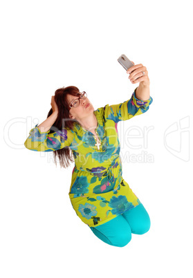 Woman taking selfie kneeling.