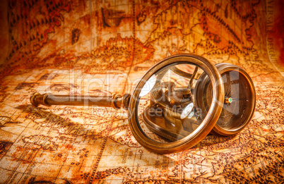 Vintage magnifying glass lies on an ancient world map