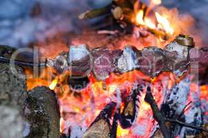 Skewers of beef, pork cooked on a campfire