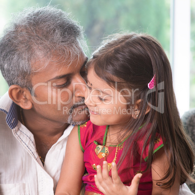 Father kissing toddler daughter