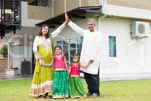 Asian Indian family outside their new home