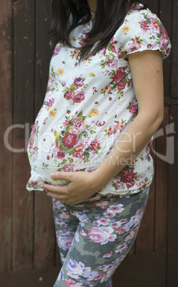 Pregnant women in front of old wooden wall