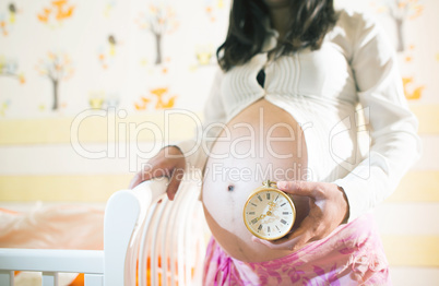 Pregnant women in a baby room.