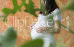 Pregnant women in front of orange wall