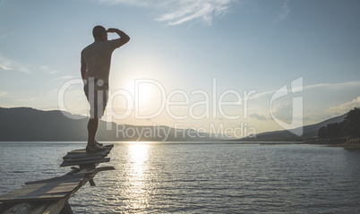 Boy in front of mountain lake