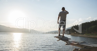 Boy in front of mountain lake