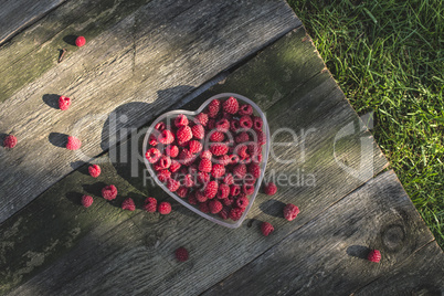 Raspberries in a bowl on wood