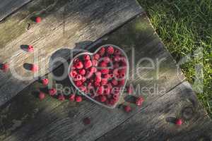 Raspberries in a bowl on wood