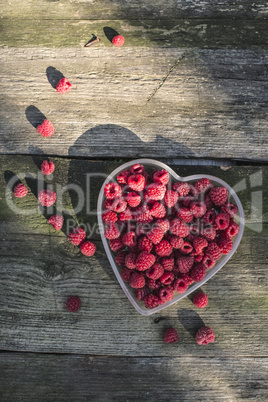 Raspberries in a bowl on wood