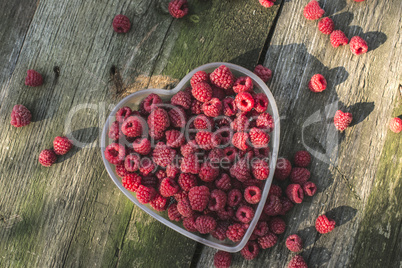 Raspberries in a bowl on wood