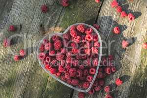 Raspberries in a bowl on wood