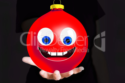 Hand holding Christmas bauble with face