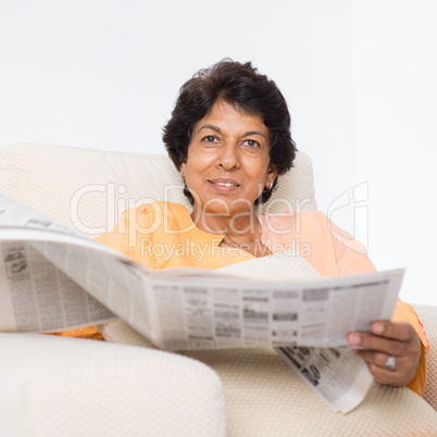 Indian mature woman reading newspaper