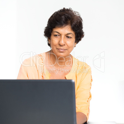 Indian mature woman using laptop computer