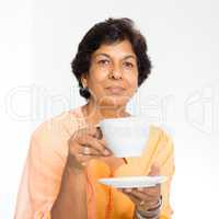 Indian mature woman drinking coffee