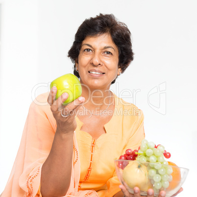 Indian mature woman eating fruits