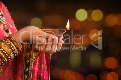 Close up Indian woman hands holding diya light
