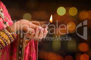 Close up Indian woman hands holding diya light