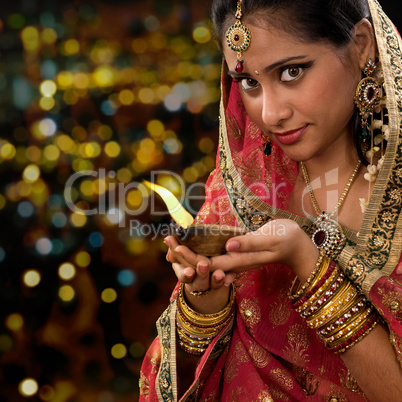 Indian woman hands holding diwali oil lamp