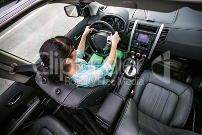 Woman behind the wheel of a car.