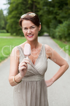 Frau im Kleid genießt im freien Ihre Eiscreme
