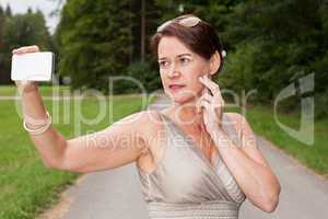 Frau im Kleid macht ein Selbstporträt mit Handy