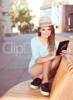 Pretty Woman with Tablet Sitting on a Modern Chair