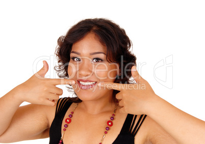 Smiling woman pointing at he teeth.