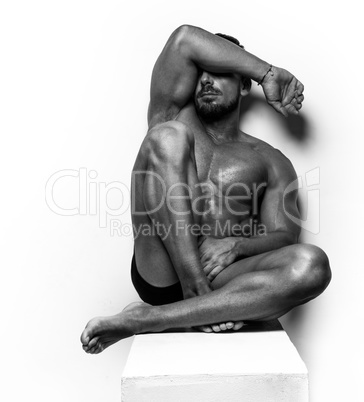 Muscular Man sitting on white