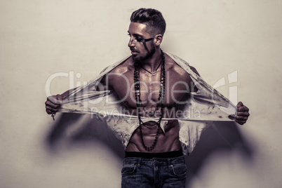 Muscular Man in Ragged Clothes ripping off his shirt
