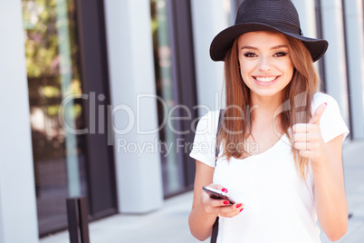 Attractive Girl with Phone Showing Thumbs Up