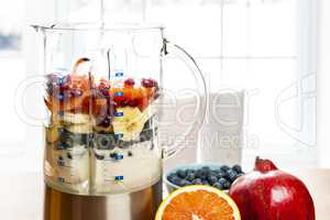 Making smoothies in blender with fruit and yogurt