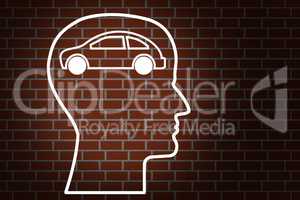Head by car on brick wall