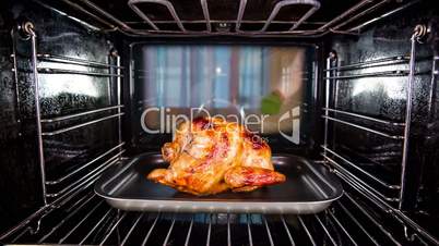 Chef prepares roast chicken (focus on chicken) in the oven, view from the inside of the oven. Cooking in the oven.Thanksgiving Day.