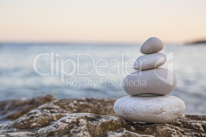 Pile of Stones on Tranquil Beach at Sunset