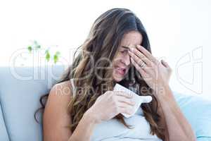 Sick woman crying on sofa