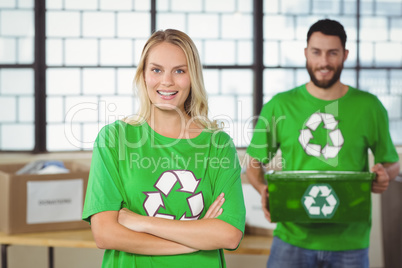 Portrait of happy woman with arms crossed standing in office