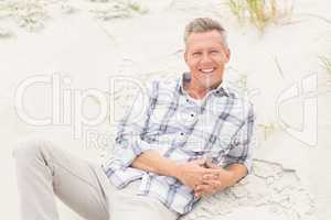 Smiling man lying on the sand