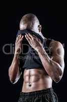 Muscular man wiping sweat with tank top