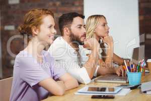 Focused business people with technologies sitting in office