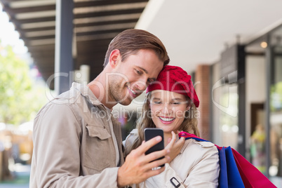 A happy couple looking at smartphone