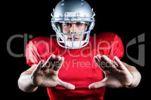 Portrait of sportsman defending while playing American football