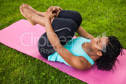 Young woman doing pilates on mat