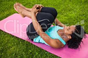 Young woman doing pilates on mat