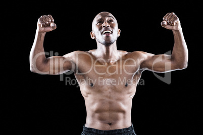 Happy shirtless athlete cheering with clenched fist