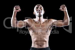 Happy shirtless athlete cheering with clenched fist