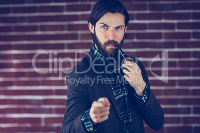 Portrait of serious man with smoking pipe pointing finger