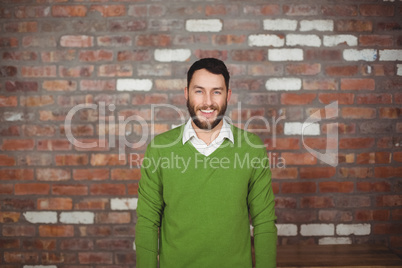 Portrait of happy businessman standing against wall